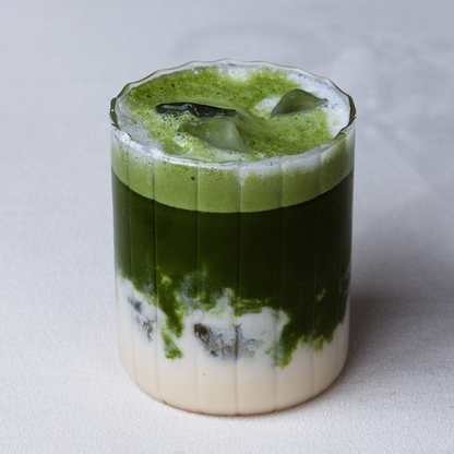 Matcha Energy Iced Latte drink with ice cubes in a glass.