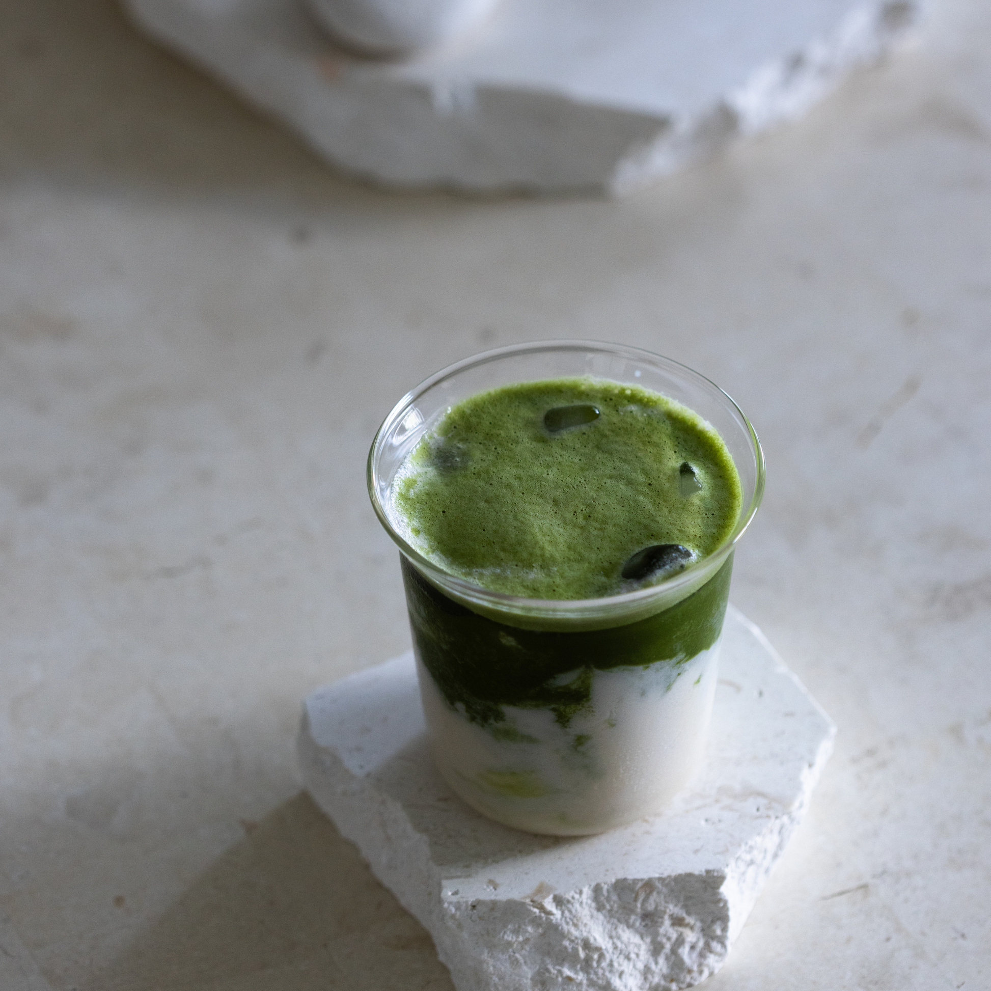 Matcha Energy layered drink in a glass on a marble surface
